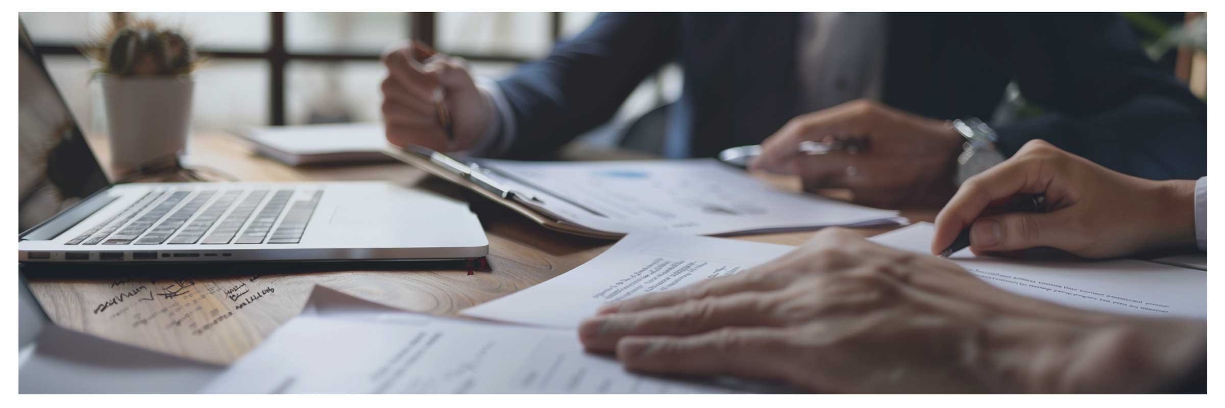 Werktafel met laptop, geprinte documenten en notities als sfeerbeeld voor consultancy en commerciële analyse.
