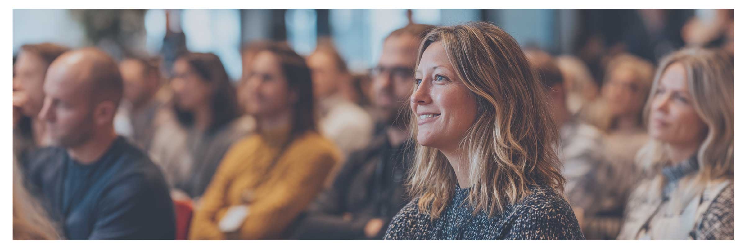 Professionals volgen een inhoudelijke sessie over sales, business development of AI tijdens een zakelijke bijeenkomst.